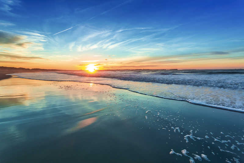 日出-日落背景下的蓝色的海滩