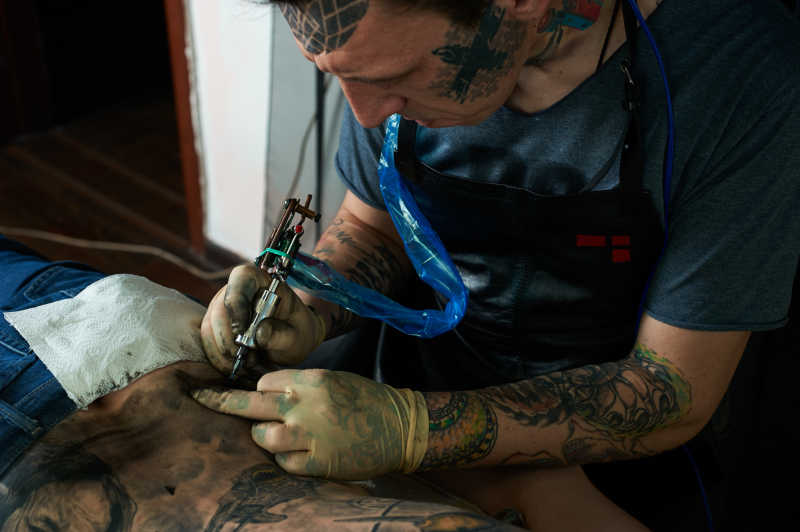 纹身师正在给背部纹身