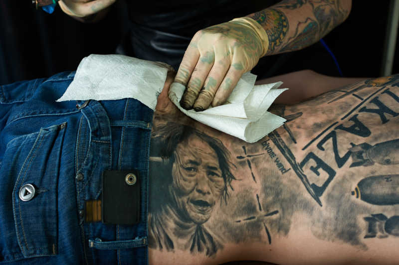 纹身师正在给顾客清洗皮肤