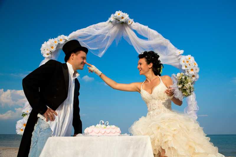 海滩的拱门下幸福的的新娘和新郎