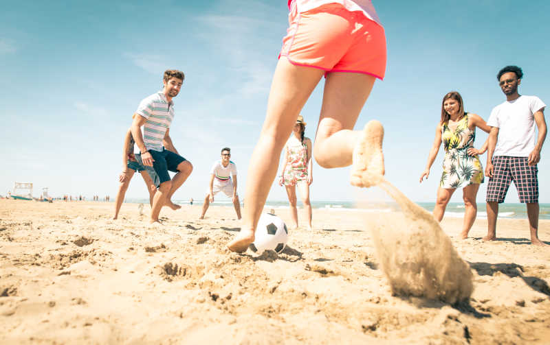 一群在海滩上踢足球的朋友