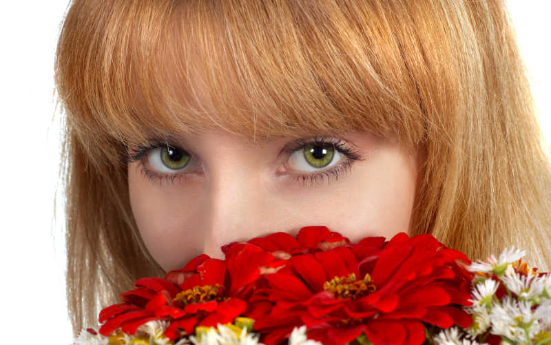 美丽女孩的绿色眼睛和红花花束