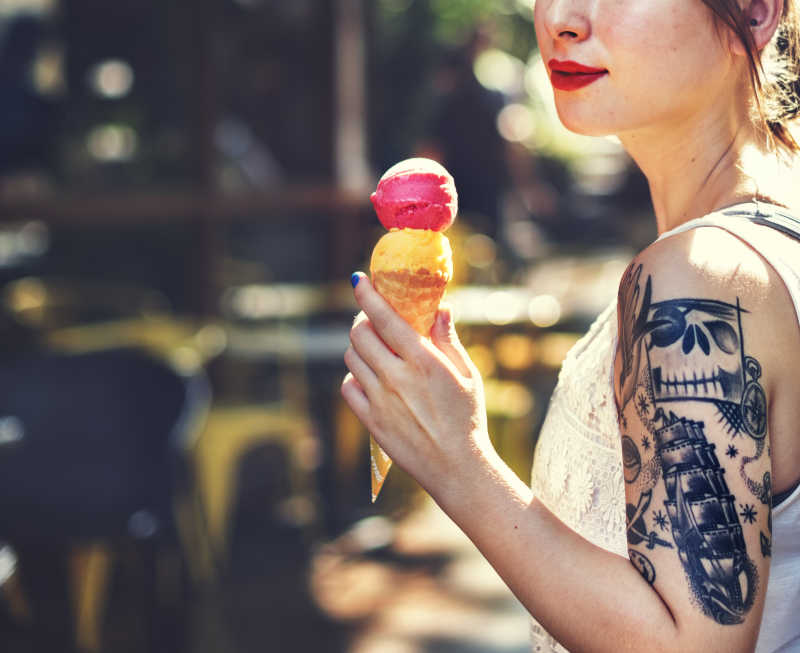 街头拿着美味冰激凌的纹身女孩