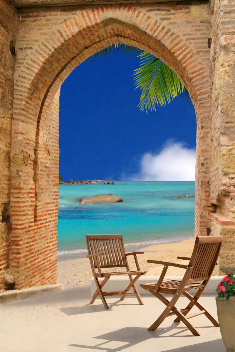 沙滩上的石拱门和木椅