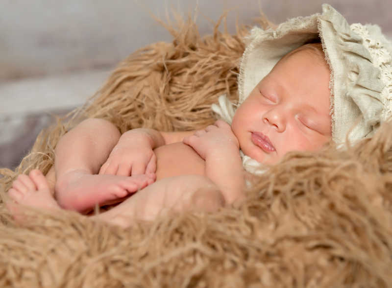 睡在松软的毯子上的初生婴儿