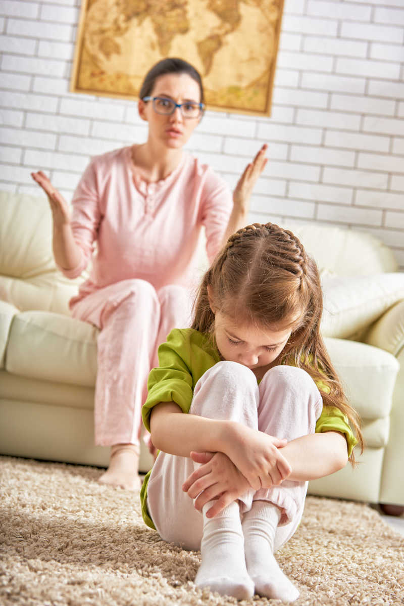 坐在沙发上母亲指责坐在地上的金发女孩