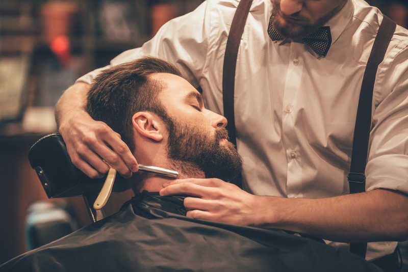 理发师在为男子刮胡子