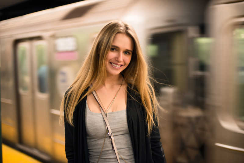 地铁列车旁微笑的女孩