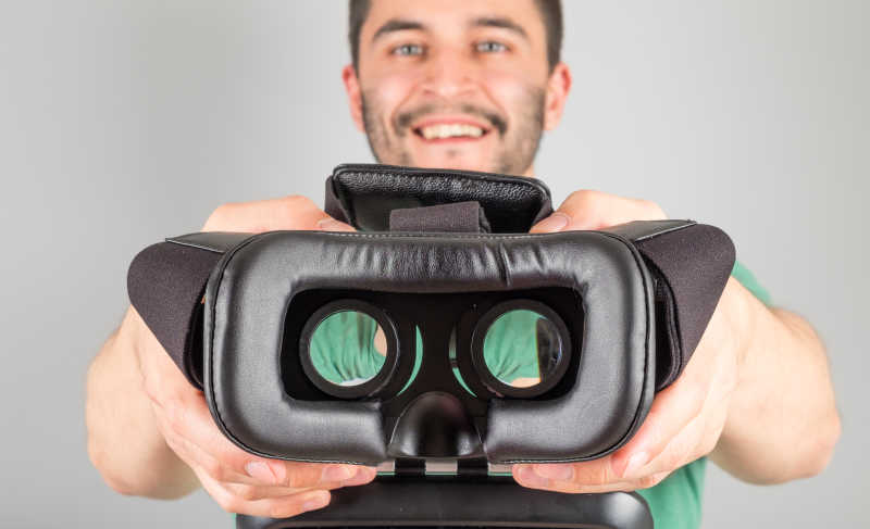 双手捧着3D虚拟眼镜的男人