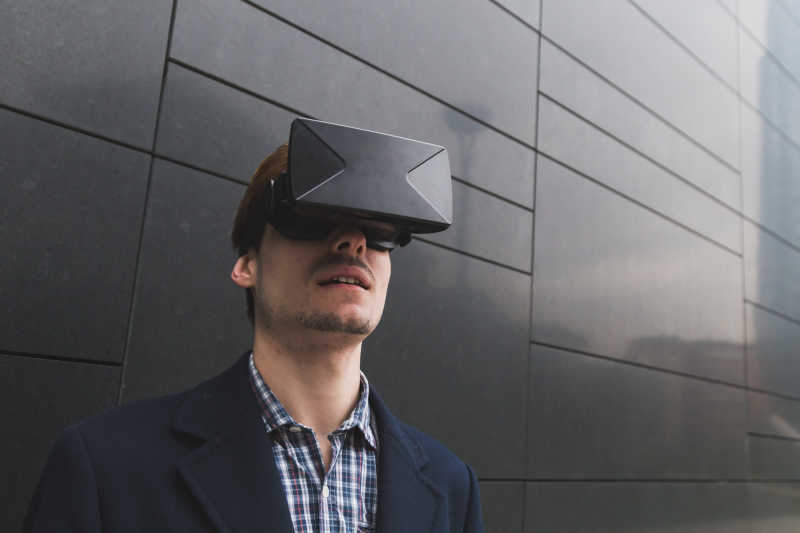 黑色瓷砖前带着3D虚拟眼镜的男人