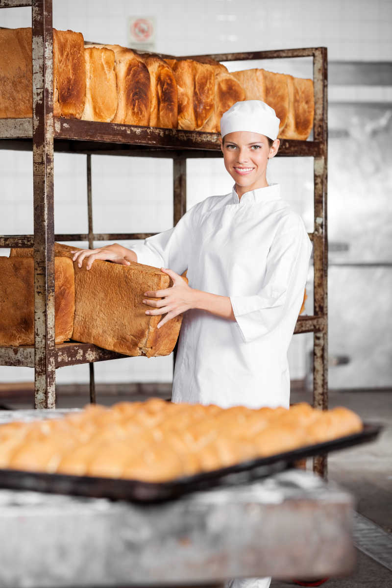 面包房取出巨大面包的女工作人员