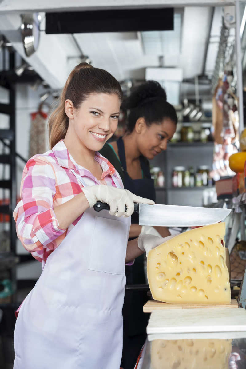 年轻女性微笑着用到切奶酪