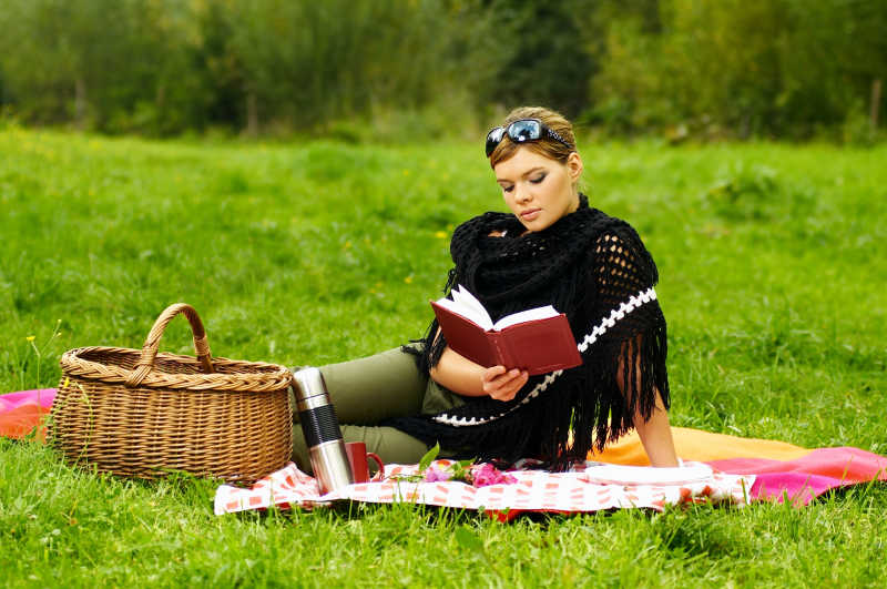 坐在草地上看书的女人