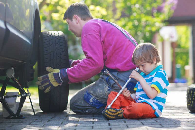 父亲和小男孩修理汽车和换轮子