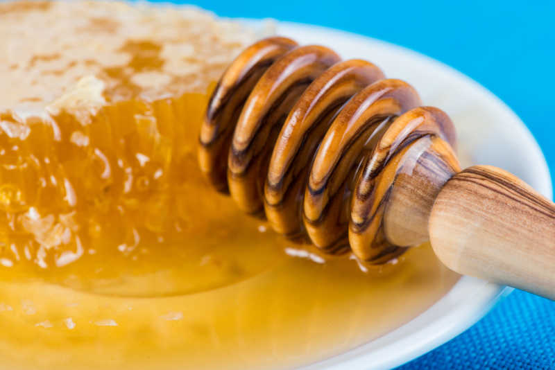 新鲜的蜂巢蜂蜜和木勺