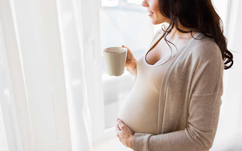 在喝水的大肚子孕妇