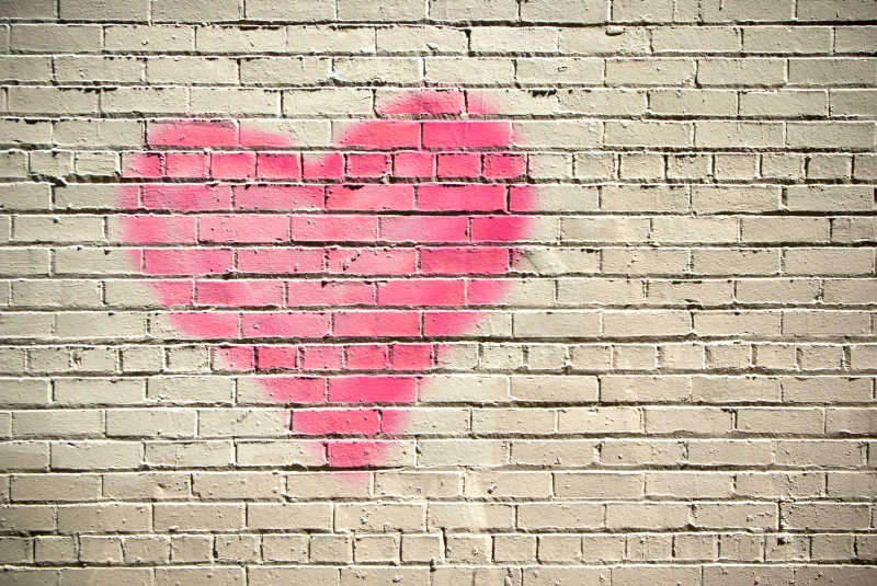白色砖墙上的粉红色心形图案