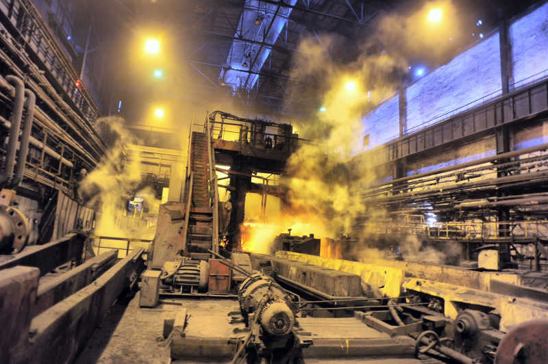 钢铁冶炼厂车间里机器正在轧制金属钢