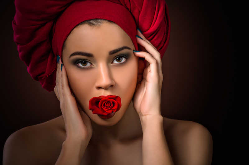 头上带着红色头套嘴里叼着玫瑰的女人