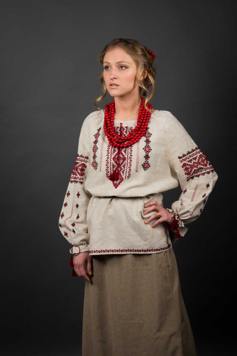 灰色背景下穿刺绣衣服的乌克兰美女