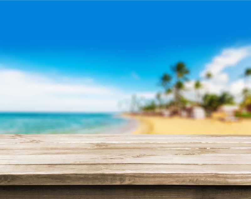 模糊的热带海滩背景前的木桌