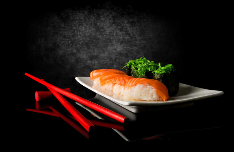 黑色背景下的寿司和筷子