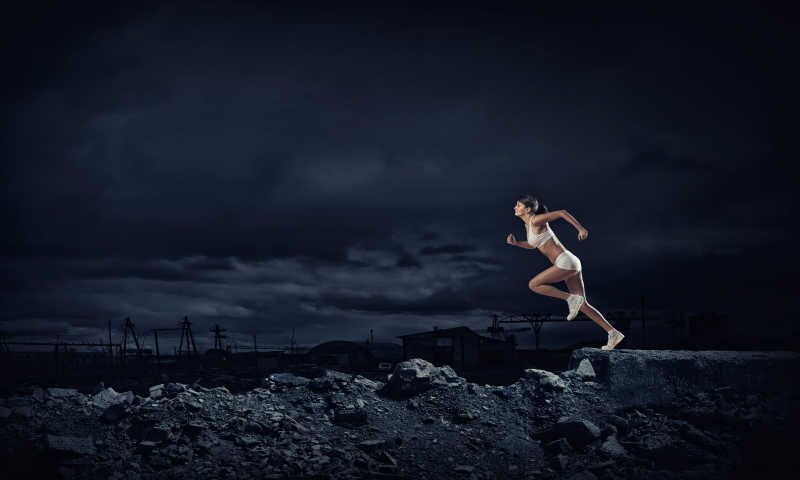 黑色背景下的美女运动员跑步概念