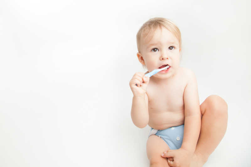 白色背景下的在刷牙的小婴儿