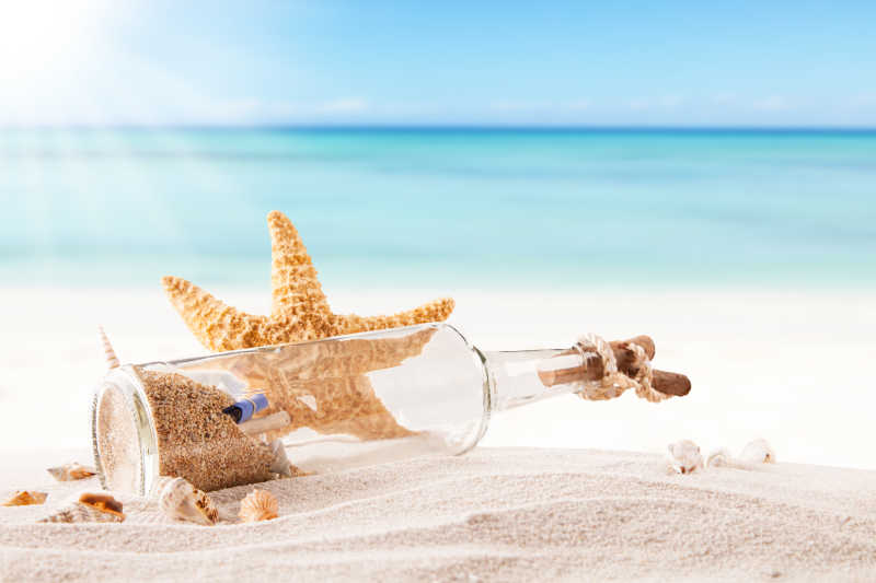 夏日沙滩上的漂流瓶和海星