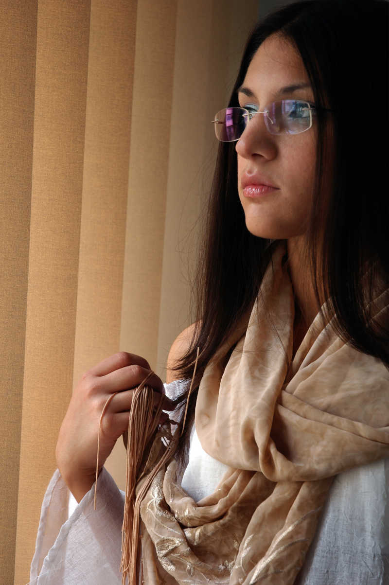 窗边戴眼镜的年轻女人