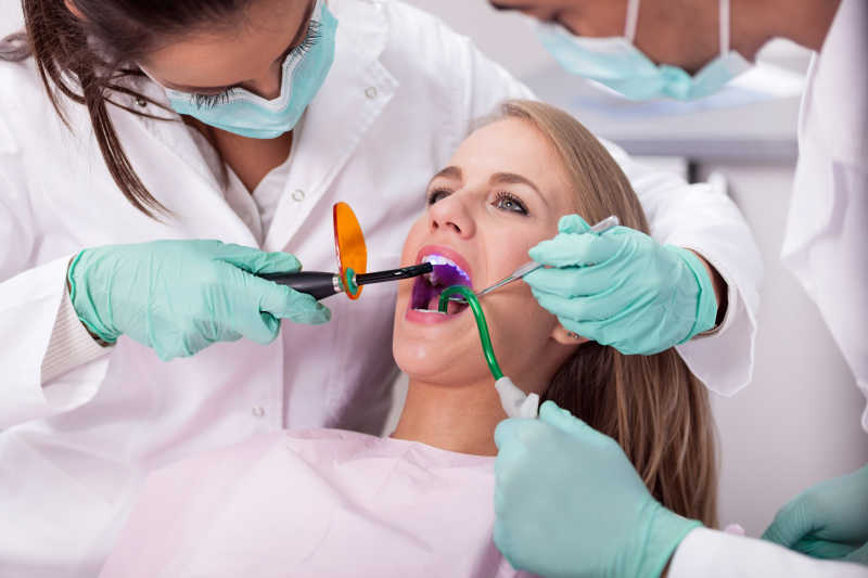 牙医在牙科医生的椅子上检查病人的口腔
