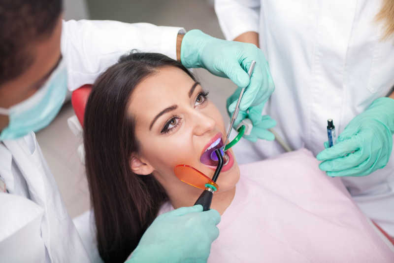牙科医生正在治疗女性患者的牙齿