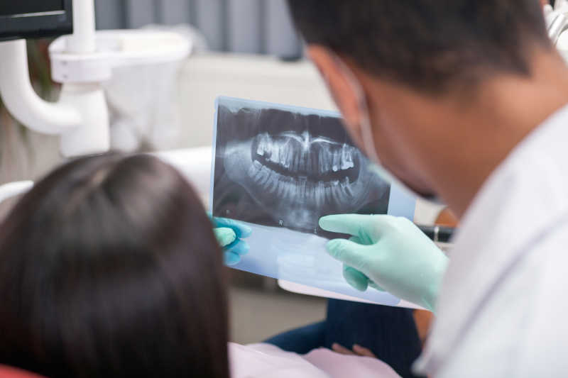 牙科医生和病人看X光图像