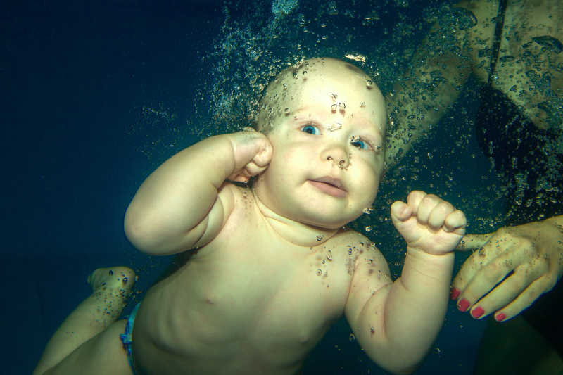 幼儿在游泳池中跳水