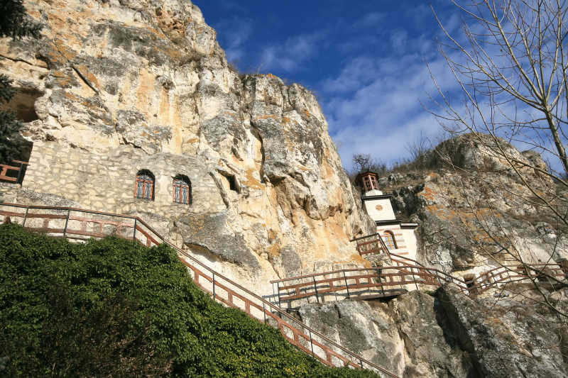 蓝天白云背景下位于山腰的岩石寺院