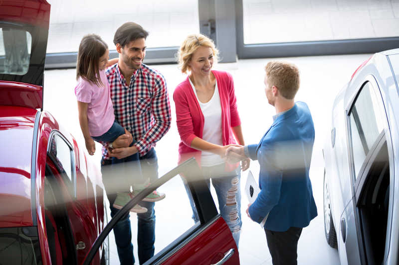 汽车经销商将汽车卖给年轻的家庭