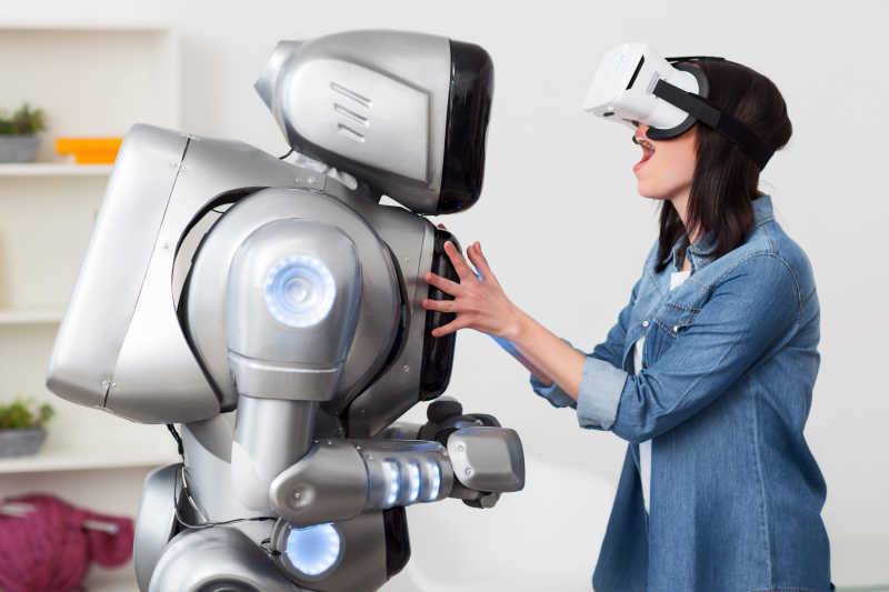 带着3D眼镜和机器人玩耍的女人