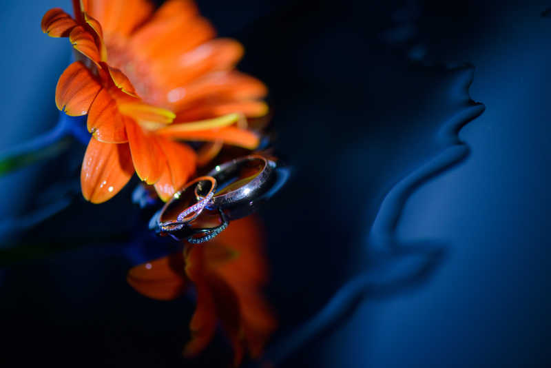 橘黄色的花朵和结婚戒指