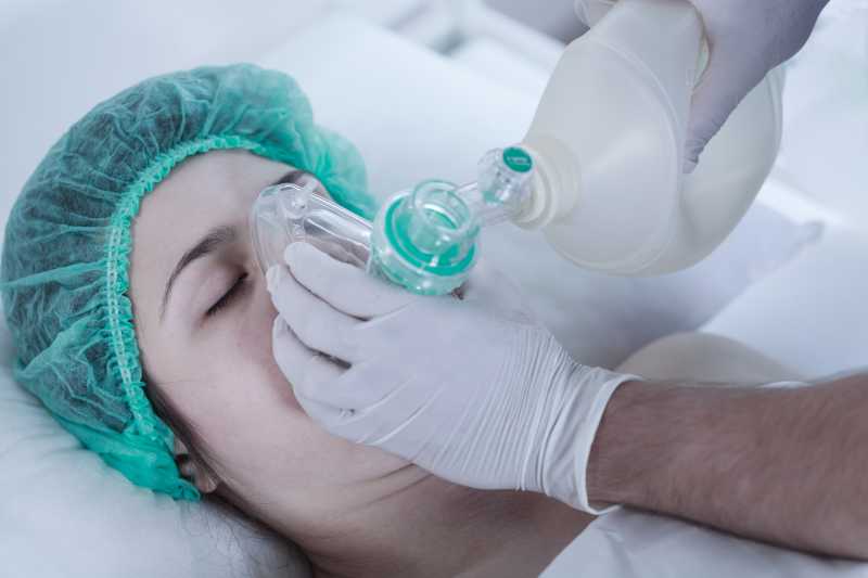 躺着使用氧气面罩的女病人