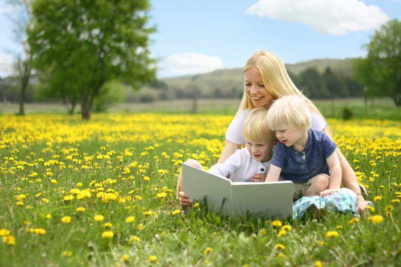 母亲和孩子在花圃看书的孩子