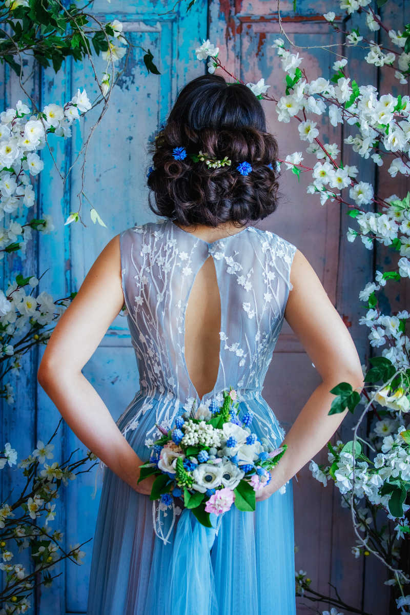 穿着华丽的礼服站在花园里的新娘