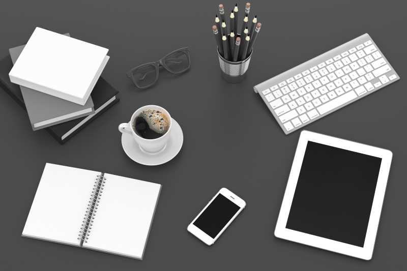 灰色桌面上的平板电脑智能手机笔记本和咖啡杯等
