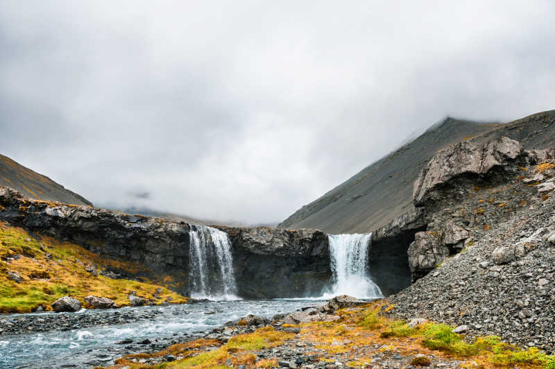 远处高耸的山和流着水的瀑布美景