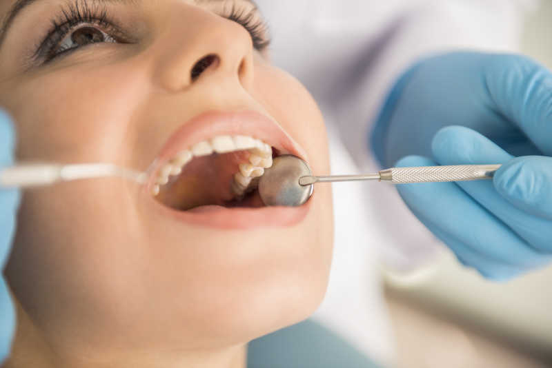 牙医在为美女患者检查牙齿
