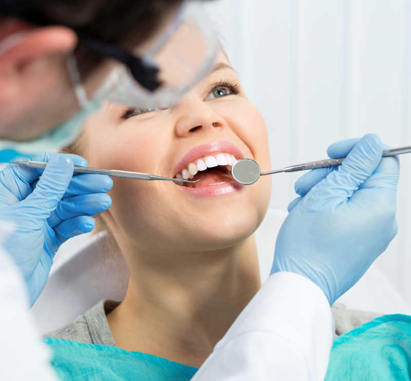口腔健康男性卫生员检查龋齿患者牙齿