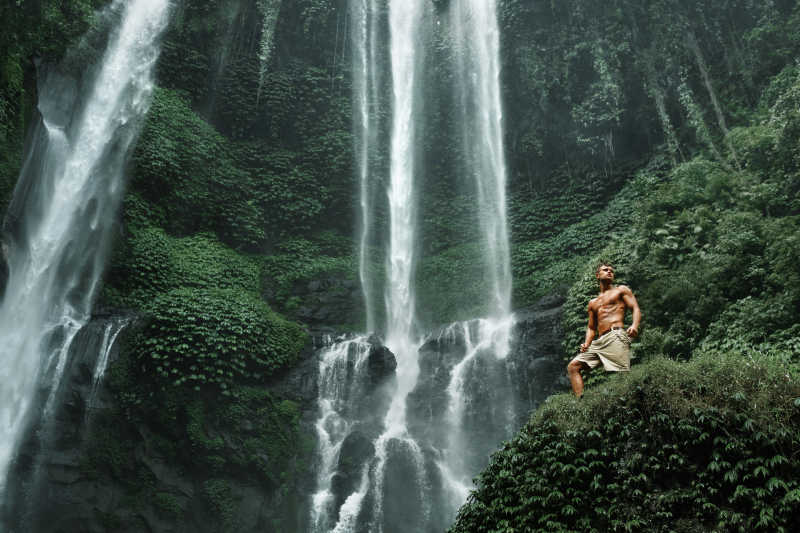 男性朋友在美丽的绿色瀑布天堂
