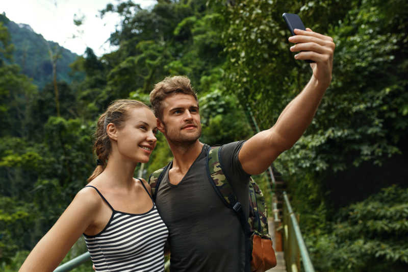一对旅游夫妇在暑假里用手机自拍
