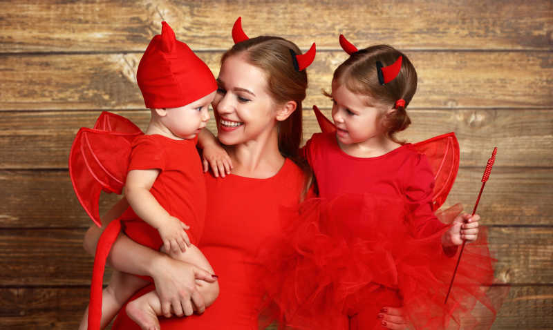 快乐的穿红色万圣节打扮的一家人