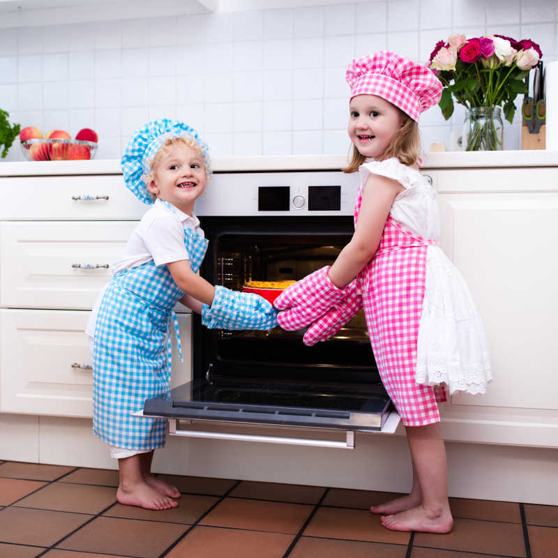 两个小孩在厨房手拉手玩耍