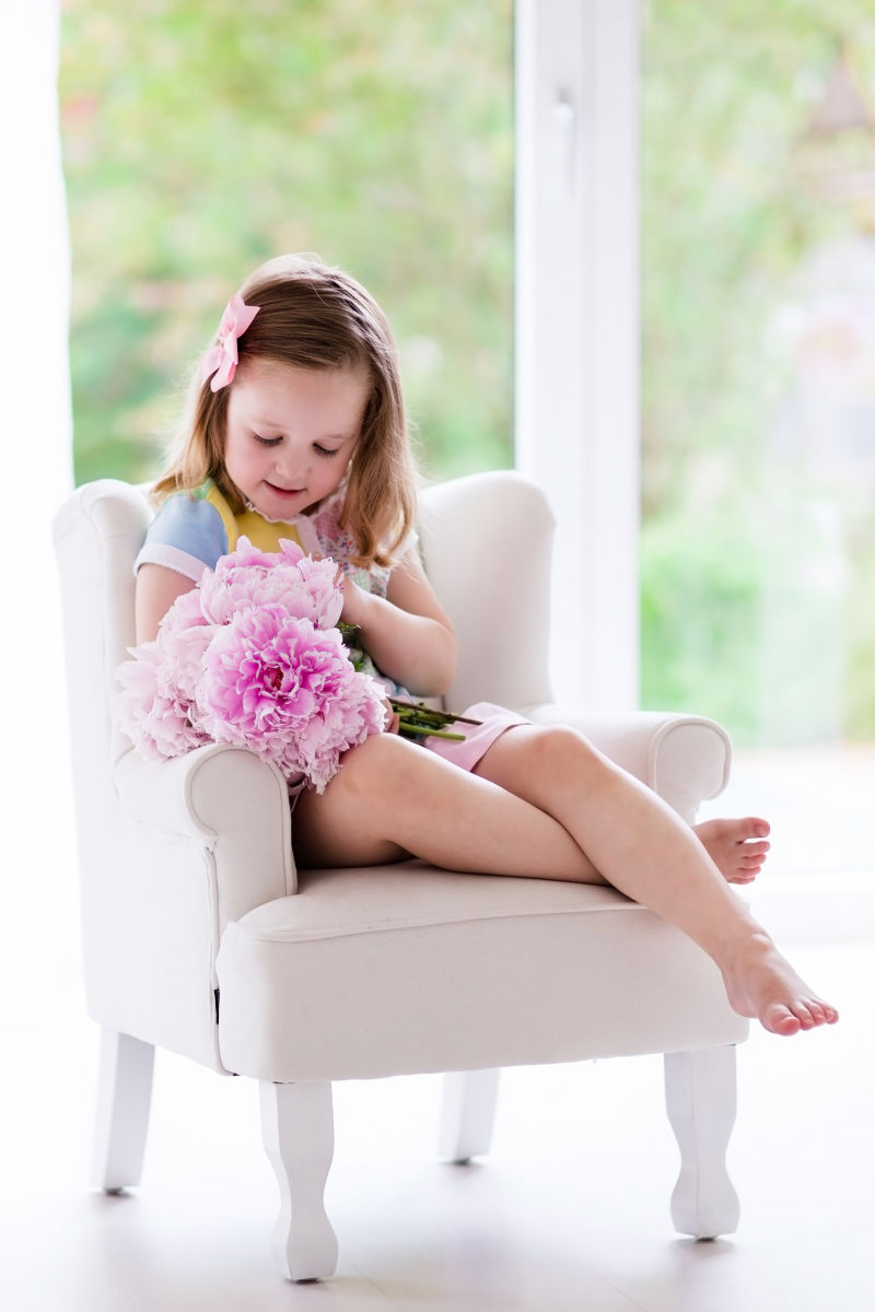 坐在沙发上拿着花束的小女孩